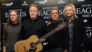 ARCHIVO - Los miembros de Eagles, de izquierda a derecha, Timothy B. Schmit, Don Henley, Glenn Frey y Joe Walsh posan con una guitarra autografiada después de una conferencia de prensa en el Festival de Cine de Sundance, el 19 de enero de 2013, en Park City, Utah. El miércoles 21 de febrero de 2024 inició un juicio penal inusual por la letra escrita a mano del éxito de rock de la banda, Hotel California. (Foto Chris Pizzello/Invision/AP, archivo)