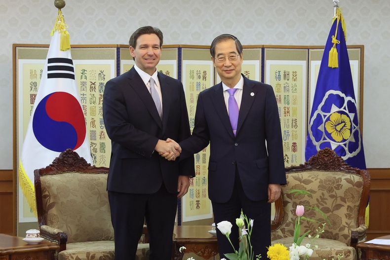 En esta imagen proporcionada por la oficina del primer ministro de Corea del Sur, el primer ministro de Corea del Sue, Han Duck-soo, a la derecha, estrecha la mano del gobernador de Florida, Ron DeSantis, en una reunión en un recinto del gobierno en Seúl, Corea del Sur, el 26 de abril de 2023. (Oficina del primer ministro de Corea via AP)