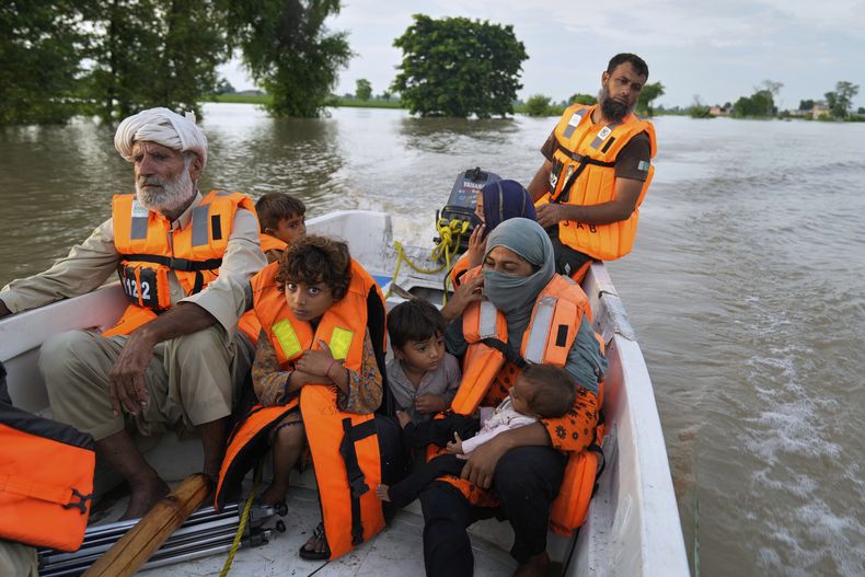 Un rescatista evacúa a residentes de una zona inundada en la localidad de Dhoop Sarhi, en el distrito de Kasur, Pakistán, el 26 de agosto de 2025, tras el desbordamiento del río Sutlej luego de que India liberase agua de sus represas desbordadas. (AP Foto/K.M. Chaudary)
