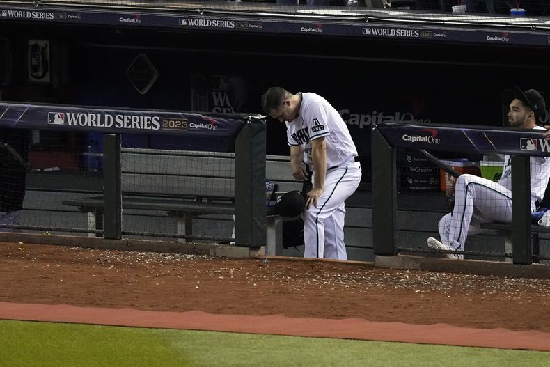 Paul Sewald, relevista de los Diamondbacks de Arizona, aparece cabizbajo durante la celebración de los Rangers de Texas en el quinto duelo de la Serie Mundial, el miércoles 1 de noviembre de 2023 (AP Foto/Ross D. Franklin)