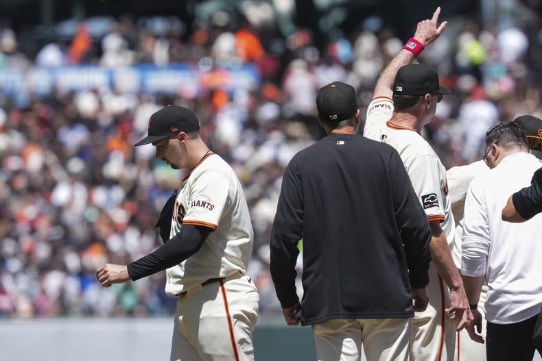 El mánager de los Gigantes de San Francisco, Bob Melvin (tercero desde la izquierda) señala al bullpen mientras el lanzador Blake Snell (izquierda) sale durante la quinta entrada del juego de béisbol ante los Yankees de Nueva York, el domingo 2 de junio de 2024, en San Francisco. (AP Foto/Godofredo A. Vásquez)