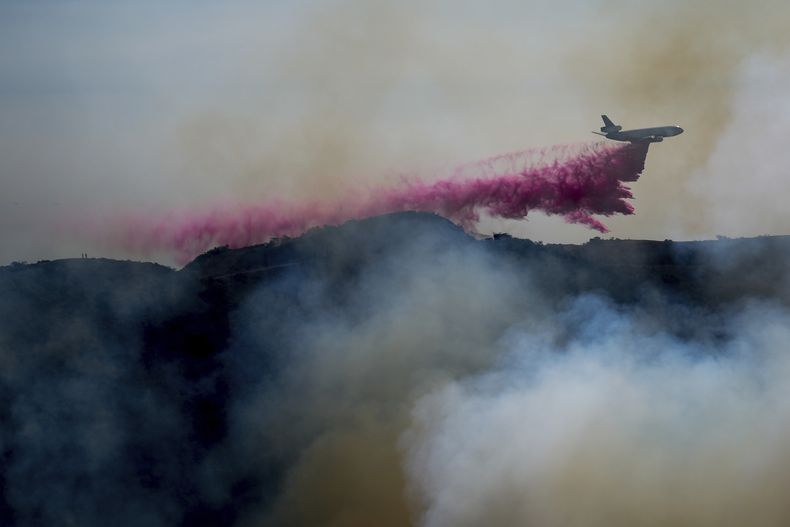 Un avión arroja retardante sobre el incendio Palisades, a las afueras del vecindario de Pacific Palisades, en Los Ángeles, el 10 de enero de 2025. (AP Foto/Eric Thayer)