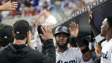 Bryan De La Cruz es felicitado por sus compañeros luego de su cuadrangular de dos carreras para los Miami Marlins en el juego ante los Filis de Filadelfia en Miami, el domingo 9 de julio de 2023. (AP Foto/Lynne Sladky)