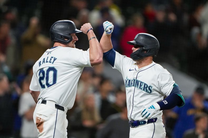 Luke Raley (20), de los Marineros de Seattle, felicita a Ty France, derecha, después de anotar con cuadrangular de dos carreras de France en contra de los Reales de Kansas City durante la octava entrada del juego de béisbol, el lunes 13 de mayo de 2024, en Seattle. (AP Foto/Lindsey Wasson)