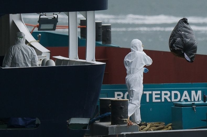Varias personas con equipo protector retiran desechos del crucero MV Hondius tras su arribo al puerto de Rotterdam, Holanda, el lunes 18 de mayo de 2026. (AP Foto/Patrick Post)
