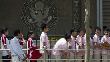 ARCHIVO - Estudiantes chinos aguardan afuera de la embajada de Estados Unidos para sus entrevistas de solicitud de visa, el 2 de mayo de 2012, en Beijing. (AP Foto/Alexander F. Yuan, archivo)