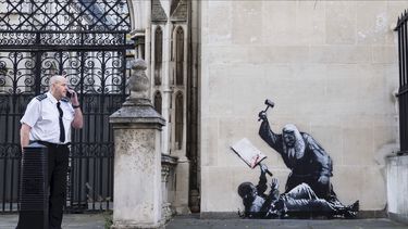 Fotografía sin fecha publicada por Banksy de la nueva obra de arte del artista que retrata a un juez golpeando a un manifestante con un mazo en los Tribunales Reales de Justicia de Londres. (Banksy via AP)