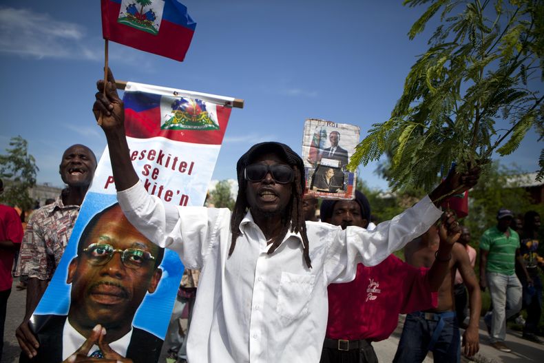 Partidarios del ex presidente Jean-Bertrand Aristide protestan contra el gobierno del presidente Michel Martelly, principalmente por elto costo de la vida, en el centro de Puerto Pr&iacute;nciope, Hait&iacute;, el jueves, 17 de octibre del 2013. (Foto AP/