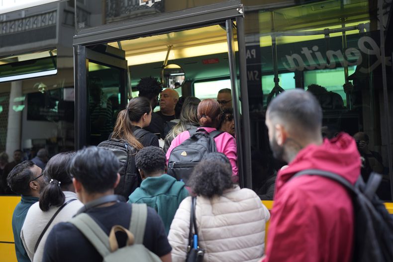 Personas intentan abordar un autobús después que el metro dejó de operar debido a un apagón en Lisboa, Portugal, el lunes 28 de abril de 2025. (AP Foto/Armando Franca)