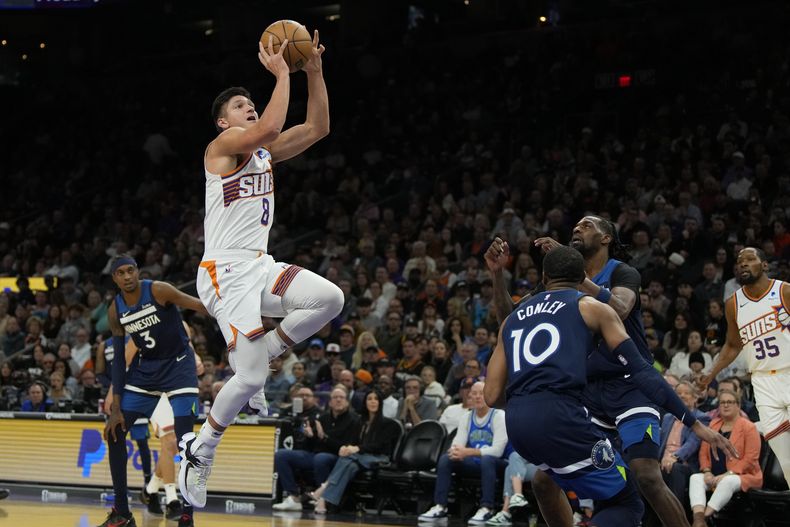 Grayson Allen, base de los Suns de Phoenix, salta para encestar en el partido del viernes 5 de abril de 2024, ante los Timberwolves de Minnesota (AP Foto/Rick Scuteri)