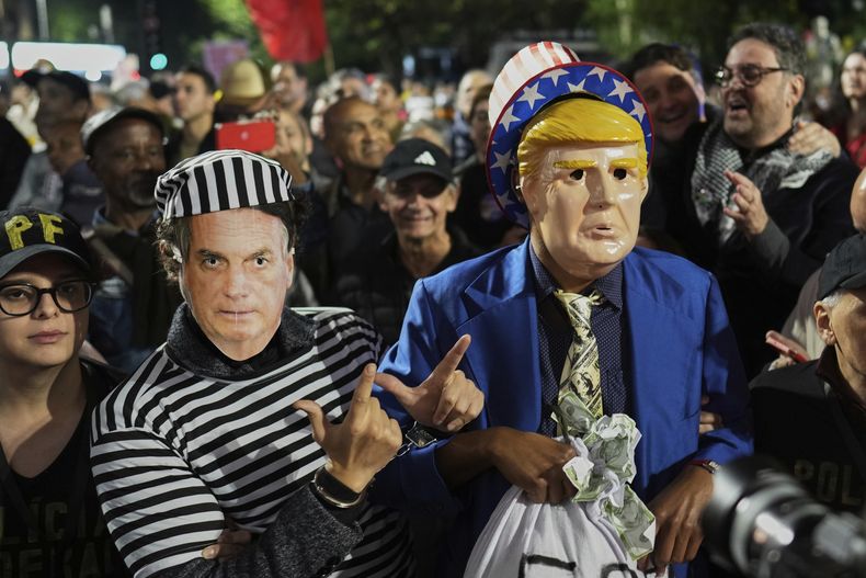 Manifestantes con máscaras del presidente estadounidense Donald Trump, derecha, y el expresidente brasileño Jair Bolsonaro protestan después de que Trump anunciara aranceles del 50% a bienes brasileños, el jueves 10 de julio de 2025, en Sao Paulo. (AP Foto/André Penner)