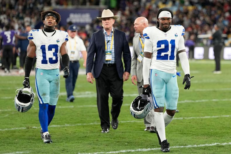 El safety Caleb Downs (13) y el cornerback Caelen Carson (21) de los Cowboys de Dallas se retiran del campo de juego tras la derrota ante los Ravens de Baltimore, el domingo 27 de septiembre de 2026, en Río de Janeiro. (AP Foto/Andre Penner)