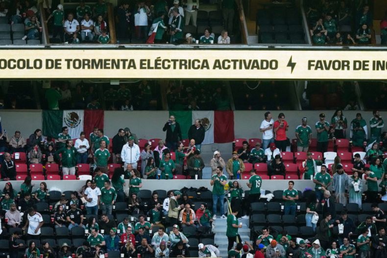 Aficionados esperan bajo la lluvia tras la demora del inicio del partido entre México e Inglaterrra en el Estadio Azteca, el domingo 5 de julio de 2026 (AP Foto/Fernando Llano)