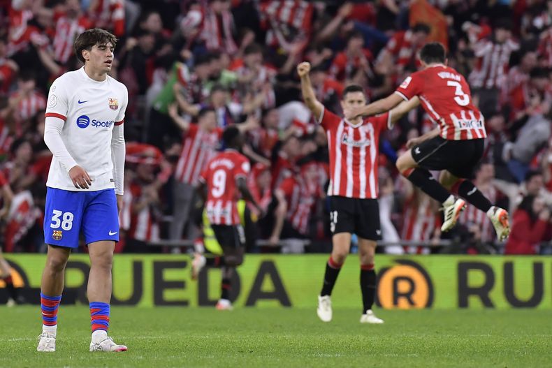 Marc Guiu, del Barcelona, abandona la cancha, mientras los jugadores del Athletic Bilbao festejan su triunfo en un partido de cuartos de final de la Copa del Rey, el miércoles 24 de enero de 2024 (AP Foto/Alvaro Barrientos)