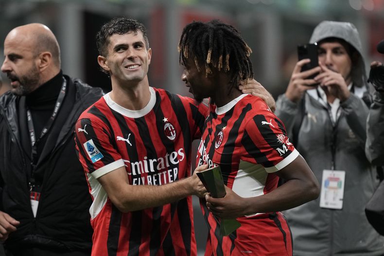 Samuel Chukwueze del AC Milan y Christian Pulisic celebran en el encuentro ante el Udinese de la Serie A el sábado 19 de octubre del 2024. (AP Foto/Antonio Calanni)