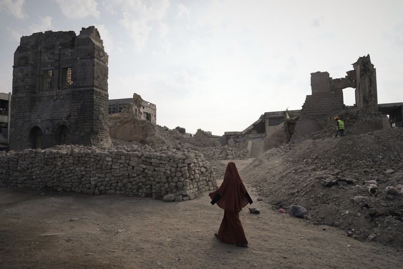 Una mujer palestina pasa por delante de las ruinas del histórico Palacio de Pachá en Ciudad de Gaza, destruido tras la campaña militar de Israel en Gaza, el jueves 13 de noviembre de 2025. (AP Foto/Jehad Alshrafi)