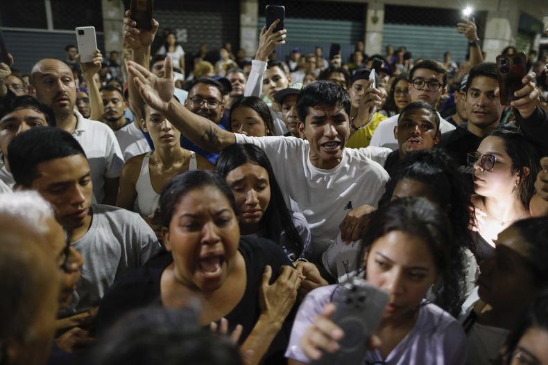 Partidarios del candidato opositor Edmundo González se reúnen frente al centro de votación de la Escuela Andrés Bello, pidiendo los resultados después del cierre de las urnas para las elecciones presidenciales en Caracas, Venezuela, el domingo 28 de julio de 2024. (AP Foto/Cristian Hernandez)