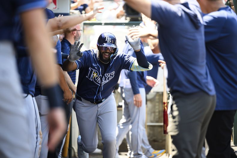 Junior Caminero, de los Rays de Tampa Bay, es recibido por sus compañeros de equipo en el dugout después de conectar un jonrón durante la tercera entrada de un partido de béisbol contra los Angelinos de Los Ángeles el miércoles 6 de agosto de 2025, en Anaheim, California. (AP Photo/William Liang)