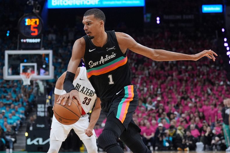 Victor Wembanyama de los Spurs de San Antonio se desmarca de Toumani Camara (33) de los Trail Blazers de Portland en los playoffs de la NBA, el domingo 19 de abril de 2026, en San Antonio. (AP Foto/Eric Gay)