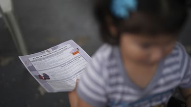 Una niña nacida en Estados Unidos se sienta en las piernas de su madre mientras Nora Sandigo, que dirige una organización sin fines de lucro dedicada a apoyar a las familias de inmigrantes, explica los derechos legales de los migrantes y las opciones que tienen para preparar a sus familias en caso de que uno de los padres sea detenido o deportado, el viernes 17 de enero de 2025, en Homestead, Florida. (AP Foto/Rebecca Blackwell)