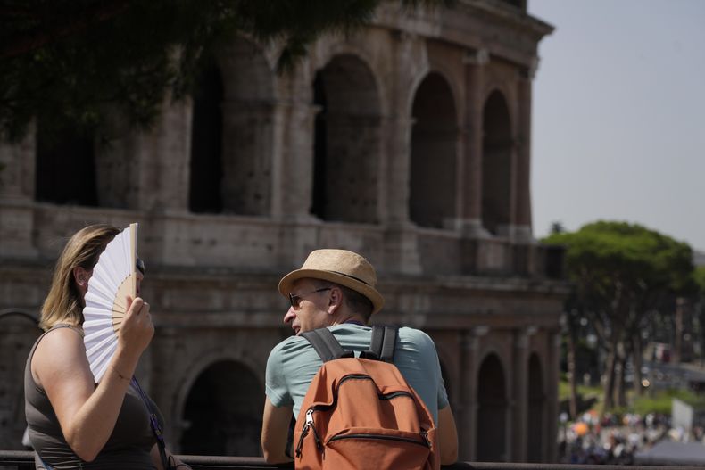 Turistas se detienen ante el Coliseo en Roma, el lunes 17 de julio de 2023. Las turistas visitaban el lunes la ciudad eterna, pese a una ola de calor que situaba Roma en la lista de las ciudades más calurosas del país. (AP Foto/Gregorio Borgia)