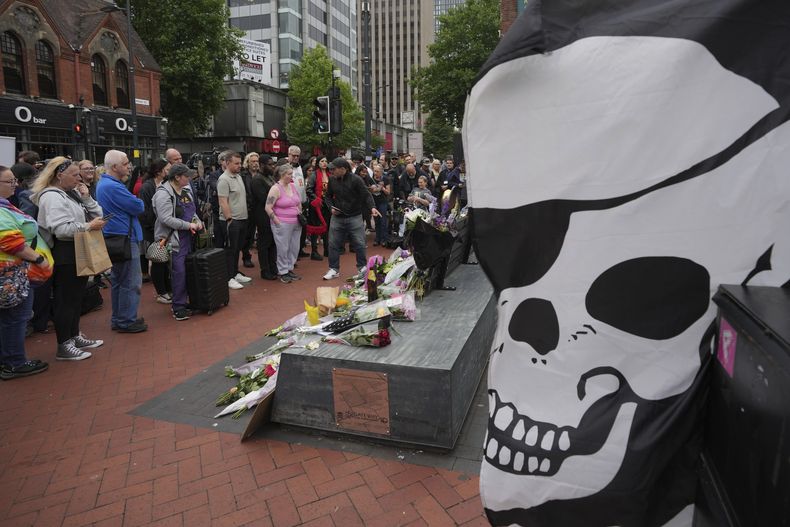 Fans depositan flores para conmemorar la muerte de Ozzy Osbourne en el puente Black Sabbath en Birmingham, el miércoles 23 de julio de 2025. (Foto AP/Kin Cheung)