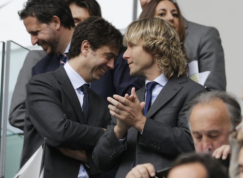 El presidente de la Juventus, Andrea Agnelli, izquierda, está flanqueado por el exfutbolista de la Juventus, Pavel Nedved, durante un partido de fútbol de la Serie A entre la Juventus y el Palermo, en el estadio de la Juventus, en Turín, Italia, el 5 de mayo de 2013. (AP Photo/Luca Bruno, Archivo)