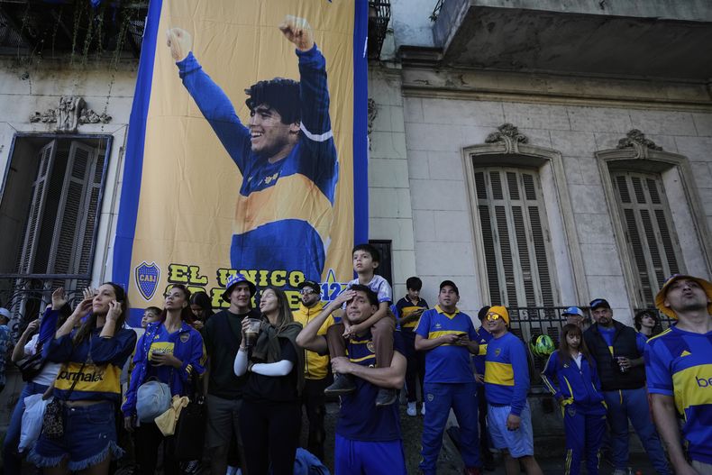 Boca Juniors siguen el partido contra River Plate por la liga local, frente a un poster de la leyenda del fútbol Diego Maradona, en el barrio de La Boca en Buenos Aires, Argentina, domingo 27 abril, 2025. (AP Foto/Natacha Pisarenko)
