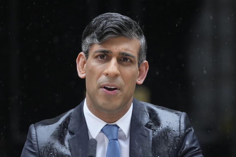 ARCHIVO - El entonces primer ministro británico, Rishi Sunak, habla mientras cae una intensa lluvia, ante el 10 de Downing Street en Londres el miércoles 22 de mayo de 2024, mientras anuncia unas elecciones generales para el 4 de julio. (AP Foto/Kin Cheung, Archivo)
