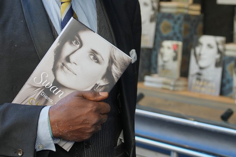 Un hombre sostiene un ejemplar del nuevo libro de Earl Spencer, hermano de la difunta princesa Diana, titulado Swan Song: Diana, My Sister, frente a una librería en el centro de Londres, el martes 22 de septiembre de 2026. (Foto AP/Kin Cheung)