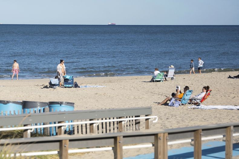 Un grupo de personas se relaja en Rehoboth Beach, Delaware, el miércoles 27 de 2025. (AP Foto/Mingson Lau)