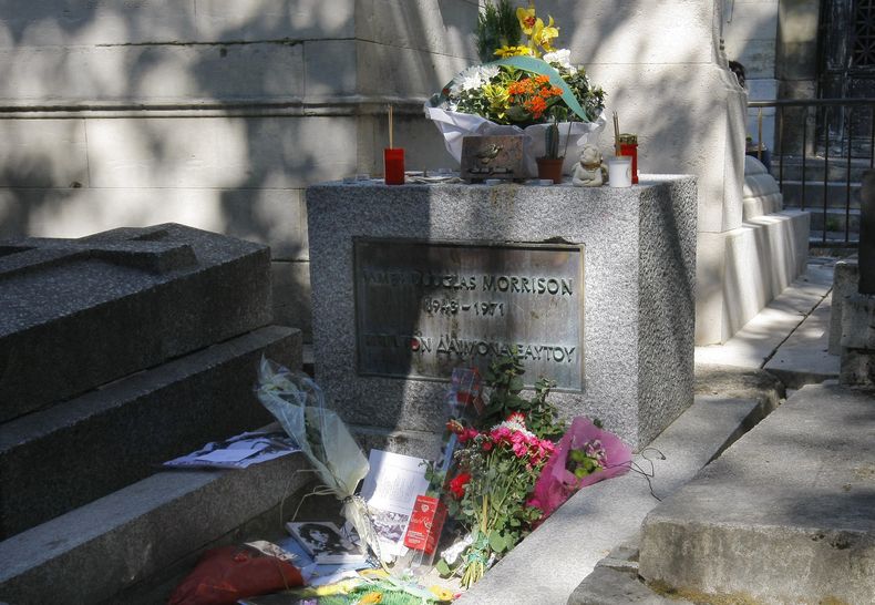 Flores y velas adornan la tumba del legendario vocalista de The Doors, Jim Morrison, en el cementerio Pere Lachaise, el lunes 3 de julio de 2011, en París. (AP Foto/Jacques Brinon, Archivo)