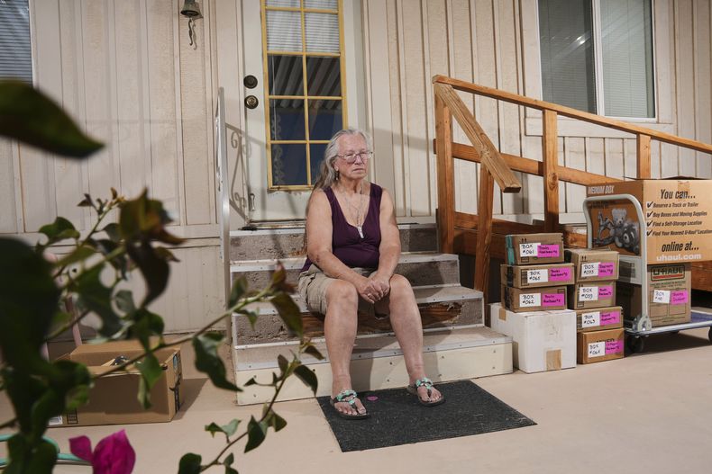 Linda Hilton, una oficinista jubilada de 76 años, se sienta frente a su casa mientras hace las maletas para mudarse, el 13 de mayo de 2025, en Apache Junction, Arizona (AP Foto/Ross D. Franklin)