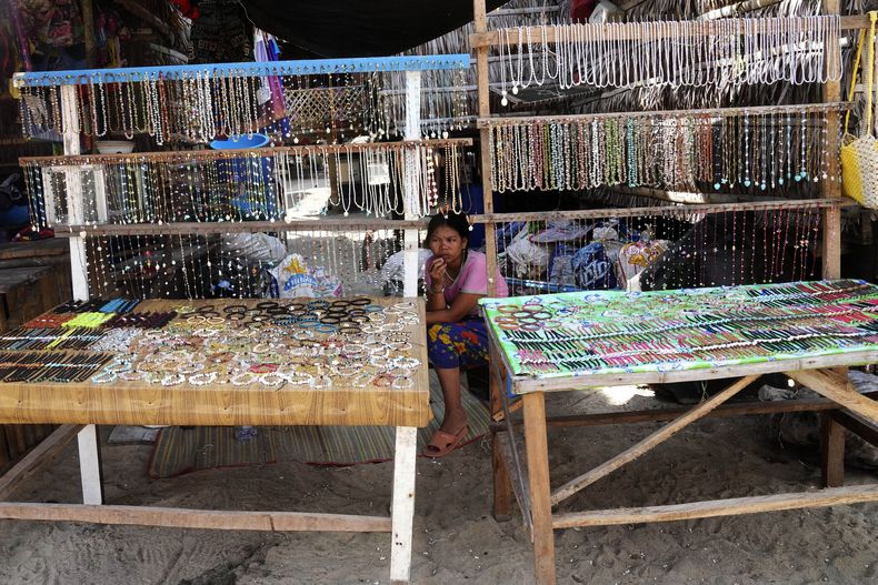 York Klathale espera a que los clientes compren recuerdos en la aldea moken de las islas Surin, en la provincia tailandesa de Phang Nga, el miércoles 11 de diciembre de 2024. (AP foto/Sakchai Lalit)