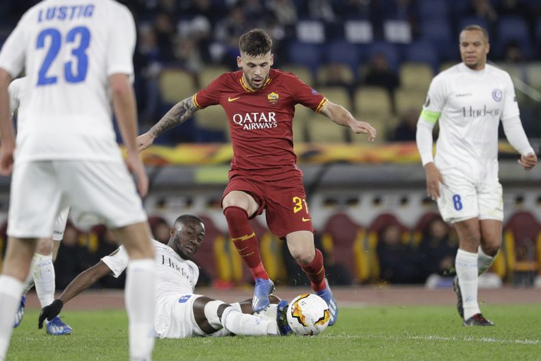 ARCHIVO - Carles Pérez, del Roma, en el centro, y Elisha Owusu, del Gent, luchan por el balón durante el partido de fútbol de ida de los dieciseisavos de final de la Liga Europa en el estadio Olímpico de Roma, el 20 de febrero de 2020. (AP Photo/Gregorio Borgia, Archivo)