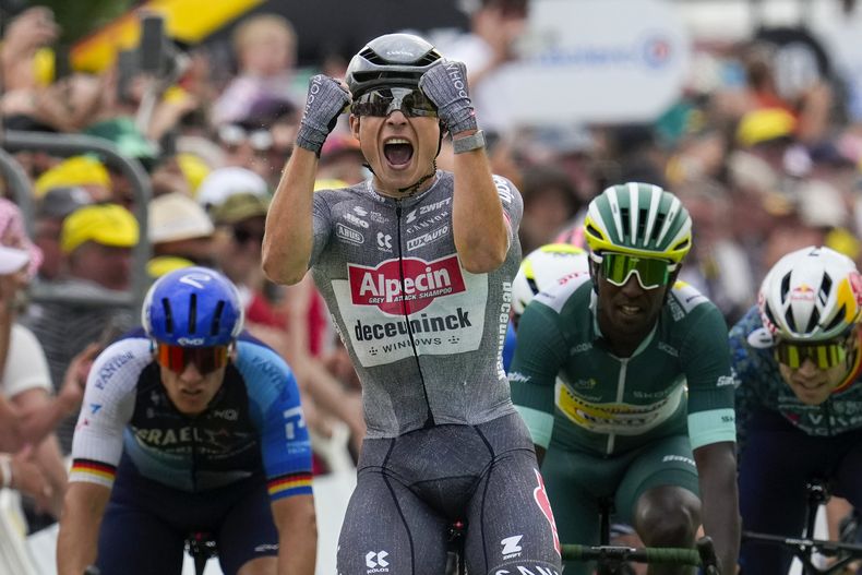 El belga Jasper Philipsen celebra al cruzar la línea de meta por delante del alemán Pascal Ackermann, a la izquierda, el eritreo Biniam Girmay, con el maillot verde de mejor velocista, y el belga Wout van Aert, a la derecha, para ganar la décima etapa del Tour de Francia de 187,3 kilómetros (116,4 millas) con salida en Orleans y llegada en Saint-Amand-Montrond. Francia, martes 9 de julio de 2024. (AP Foto/Jerome Delay)