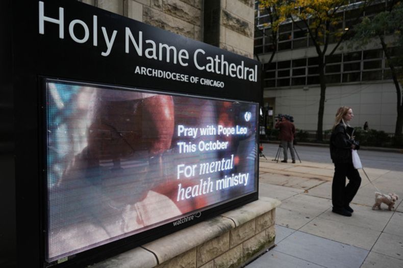 Una persona camina frente a un letrero en el que la Catedral del Santo Nombre hace un llamado para pedir por la salud del papa León XIV después de su diagnóstico de cáncer de pulmón, el miércoles 14 de octubre de 2026, en Chicago. (AP Foto/Nam Y. Huh)