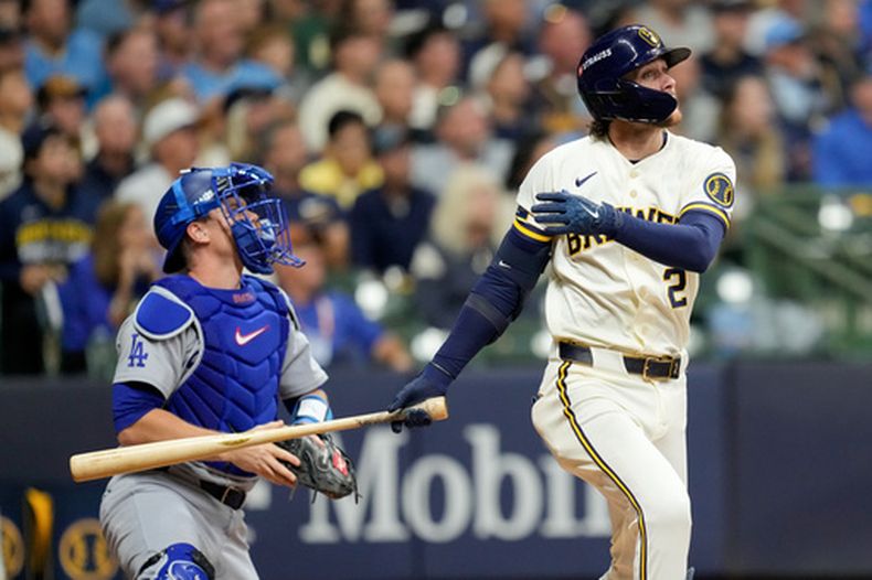 El segunda base de los Cerveceros de Milwaukee, Brice Turang, y el receptor de los Dodgers de Los Ángeles, Will Smith, observan el vuelo de su jonrón solitario durante la cuarta entrada del primer juego de la serie de campeonato de la Liga Nacional de béisbol entre los Cerveceros de Milwaukee y los Dodgers de Los Ángeles, el domingo 11 de octubre de 2026, en Milwaukee. (Foto AP/Ashley Landis)