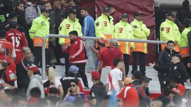 Agentes policiales y empleados de seguridad resguardan la zona donde falleció un espectador, al caer desde la tribuna durante el partido de River Plate contra Defensa y Justicia en Buenos Aires, el sábado 3 de junio de 2023 (AP Foto/Nicolas Aboaf)