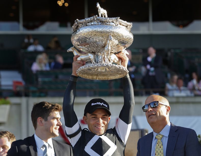 ARCHIVO - El jinete Joel Rosario, en el centro, sostiene el Trofeo Belmont de agosto después de ganar la 151ª carrera de caballos Belmont Stakes, el sábado 8 de junio de 2019, en Elmont, Nueva York. El ganador de la Triple Corona Justify, Caballo del Año 2017 Gun Runner y el jinete Joel Rosario han sido elegidos para el Museo Nacional de Carreras y el Salón de la Fama en su primer año de elegibilidad. (AP Foto/Eduardo Muñoz Álvarez, Archivo)