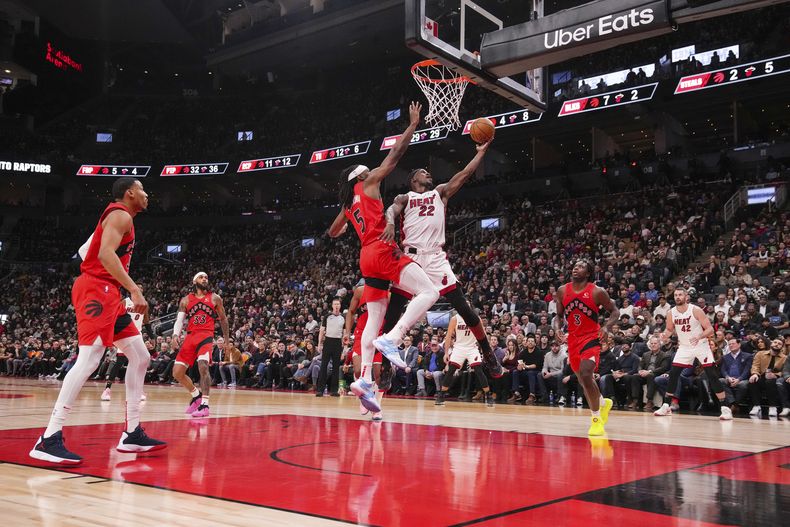 Jimmy Butler del Heat de Miami lanza el balón mientras lo defiende Precious Achiuwa de los Raptors de Toronto en el encuentro de la NBA el miércoles 6 de diciembre del 2023. (Chris Young/The Canadian Press via AP)