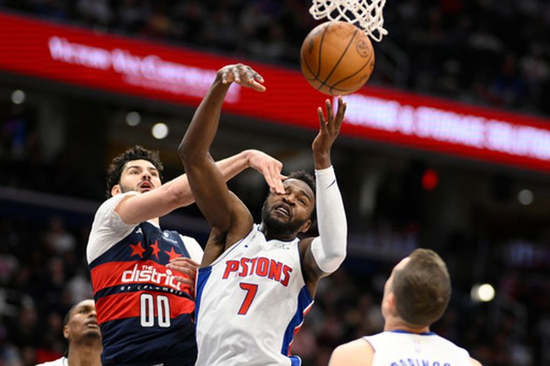 El alero de los Pistons de Detroit, Paul Reed (7), y el alero de los Wizards de Washington, Tristan Vukcevic (00), luchan por el balón durante la primera mitad de un juego de baloncesto de la NBA, el jueves 19 de marzo de 2026, en Washington. (Foto AP/Nick Wass)