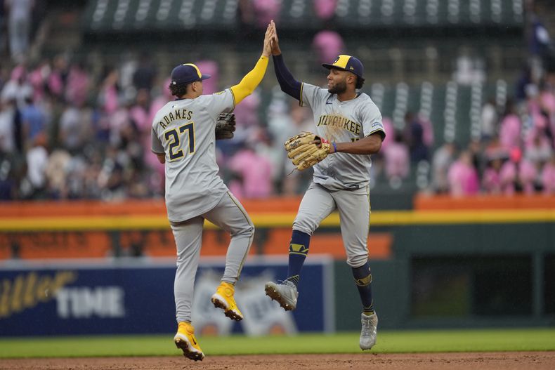 El campocorto de los Cerveceros de Milwaukee, Willy Adames (27), y Jackson Chourio celebran después del último out contra los Tigres de Detroit en la novena entrada, el sábado 8 de junio de 2024, en Detroit. (AP Foto/Paul Sancya)