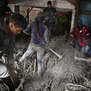 Los residentes ayudan a los rescatistas a desenterrar el lodo de las casas destruidas mientras buscan víctimas o sobrevivientes de un deslizamiento de tierra durante las fuertes lluvias en Las Tejerias, estado de Aragua, Venezuela, el 9 de octubre de 2