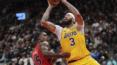 Anthony Davis, de los Lakers de Los Ángeles, dispara frente a Davion Mitchell, de los Raptors de Toronto, en el encuentro del viernes 1 de noviembre de 2024 (Frank Gunn/The Canadian Press via AP)