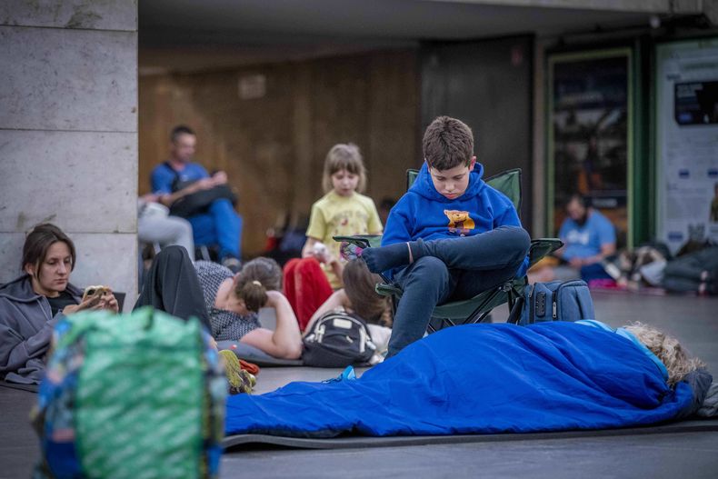 Varias personas se esconden en una estación de metro, utilizada como refugio antiaéreo, durante un ataque con drones rusos en Kiev, Ucrania, la madrugada del sábado 5 de julio de 2025. (AP Foto/Dan Bashakov)