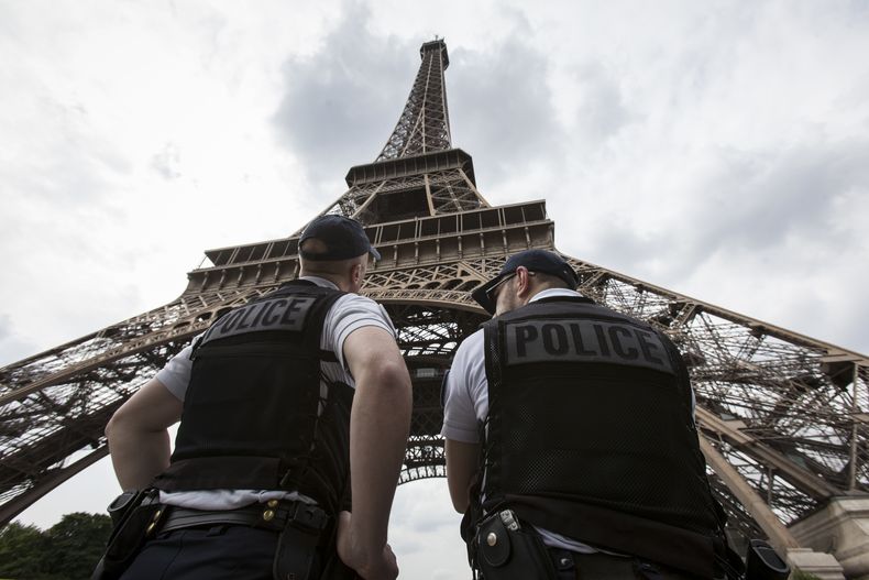 ARCHIVO - Unos agentes de la policía antidisturbios de Francia patrullan debajo de la Torre Eiffel, en París, el 10 de junio de 2016. (AP Foto/Kamil Zihnioglu, Archivo)