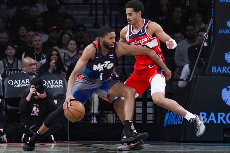 Mikal Bridges (izquierda) de los Nets de Brooklyn conduce ante Jordan Poole de los Wizards de Washington, durante el juego de NBA el domingo 12 de noviembre de 2023, en Nueva York. (AP Foto/Bebeto Matthews)