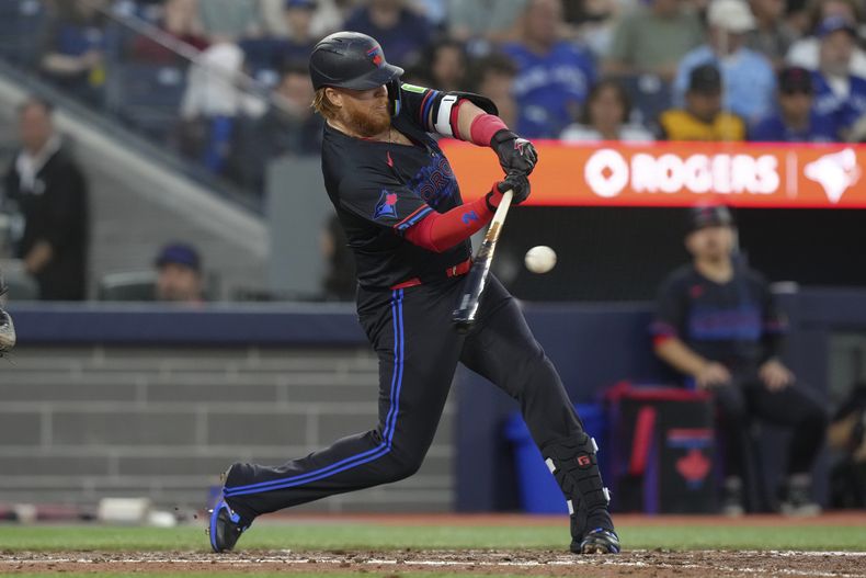 Justin Turner, de los Azulejos de Toronto, batea un sencillo durante la sexta entrada en contra de los Rays de Tampa Bay, en Toronto, el miércoles 24 de julio de 2024. (Chris Young/The Canadian Press vía AP)