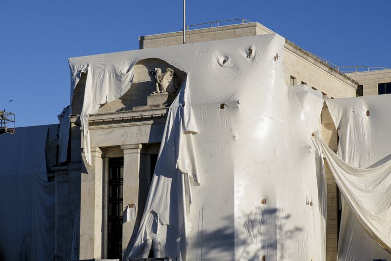 ARCHIVO - La escultura de un águila se observa entre la envoltura protectora de la fachada del edificio de la Junta de la Reserva Federal, que se somete a renovaciones interiores y exteriores, en Washington, el lunes 23 de octubre de 2023. (AP Foto/J. Scott Applewhite, archivo)
